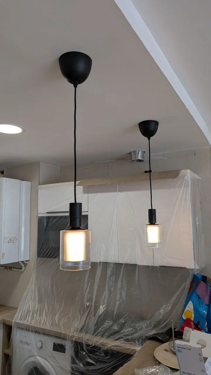 Luminarias colgantes instaladas sobre una cocina durante una reforma