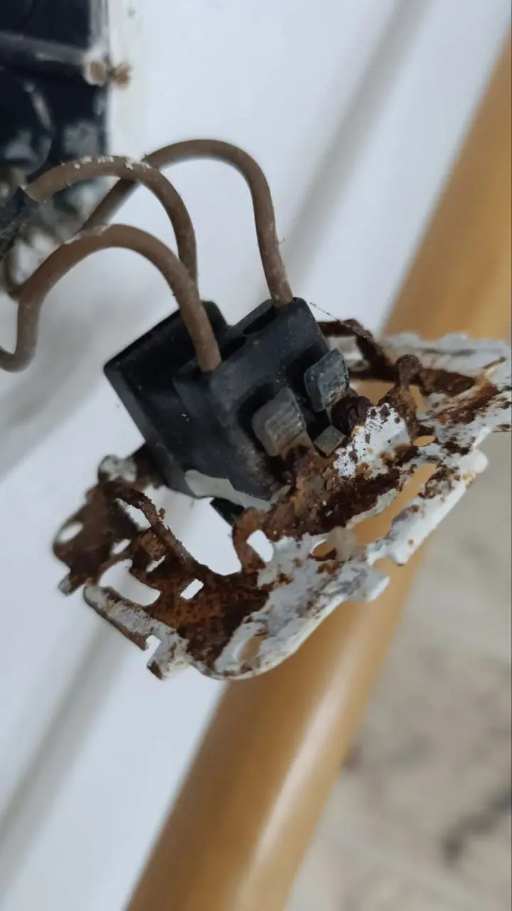 Interruptor eléctrico oxidado y deteriorado que debe ser revisado por un electricista
