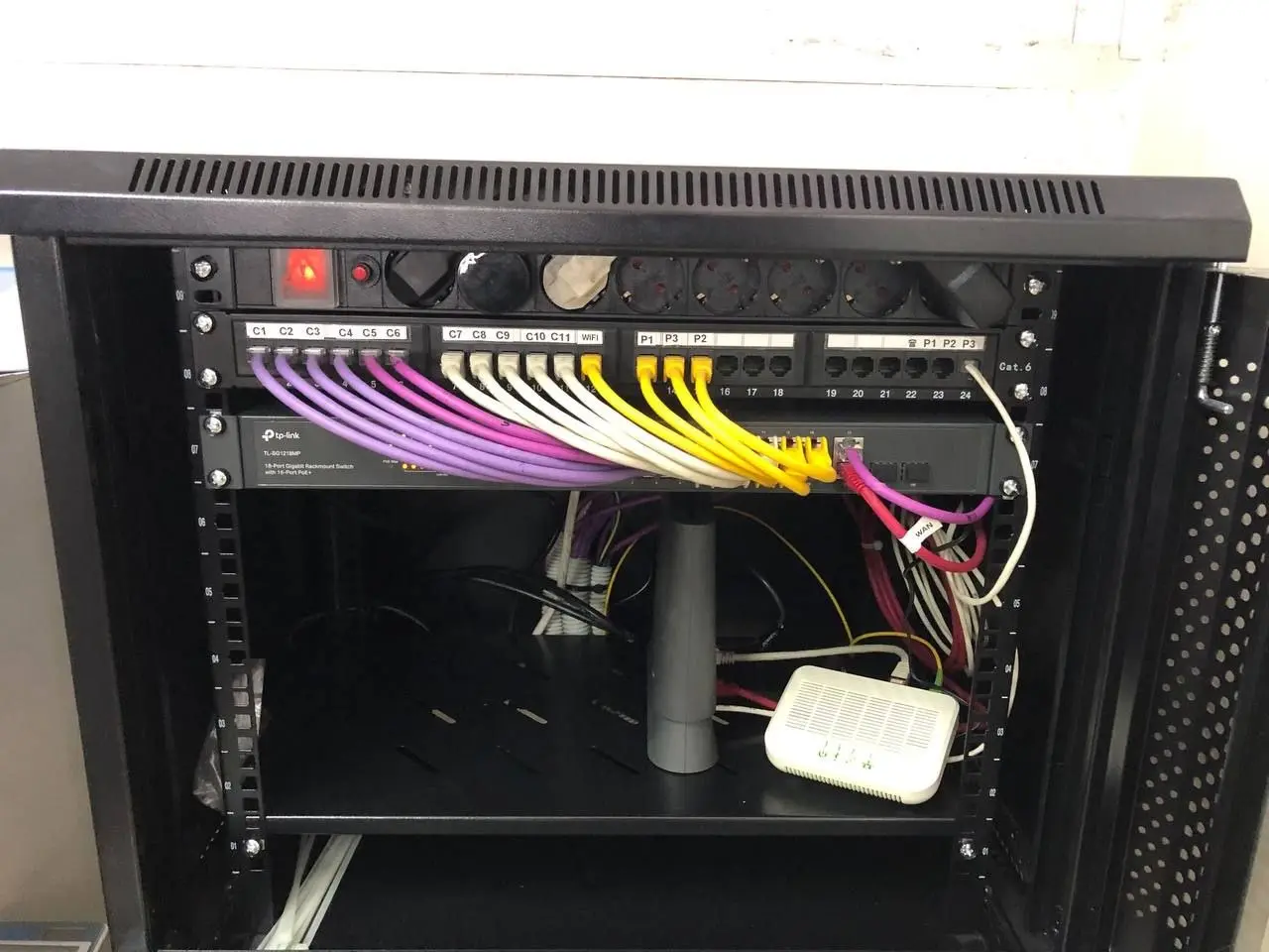 Rack con switch, patch panel y conexiones de red instalado por Elektel