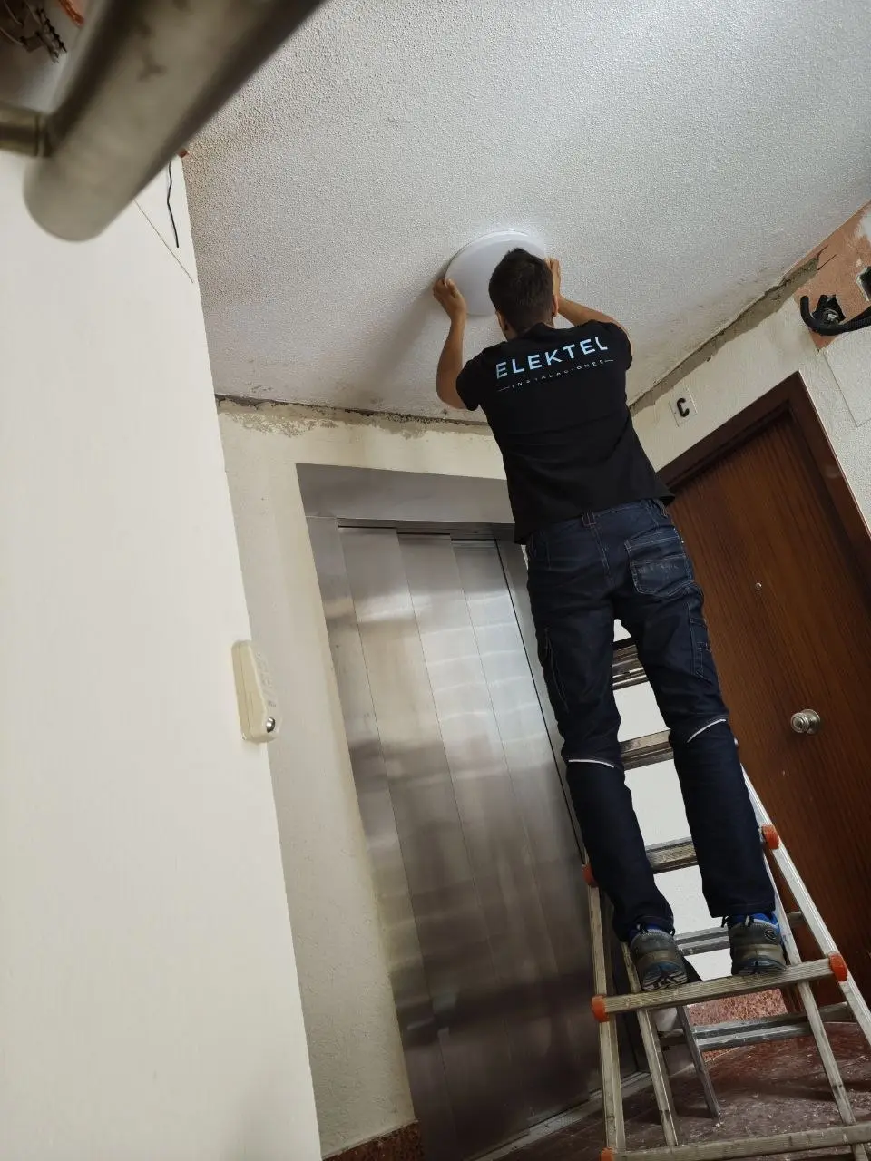 Técnico electricista de Elektel instalando iluminación en un portal del País Vasco